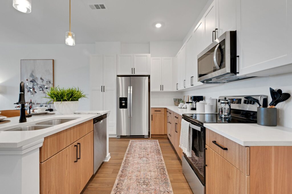 RISE Viera 55+ apartment community in Melbourne, FL kitchen view looking at the fridge and featuring stainless steel appliances